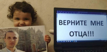 Nadzhiye Mustafayeva (youngest child of Server Mustafayev) with a photo of her father, next to the message Bring my father back Photo Crimean Solidarity